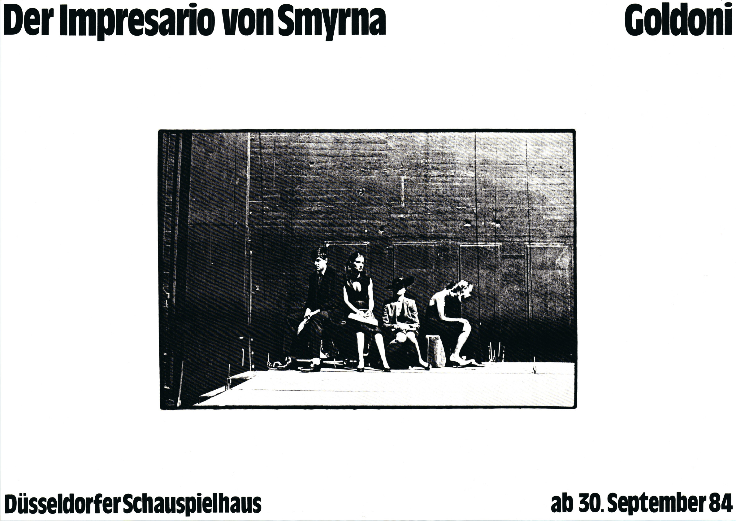 schwarz-weißes Schriftplakat mit der Abbildung eines Szenenfotos im Zentrum, das vier wartende Schauspielerinnen und Schauspieler zeigt, die, zum Teil zusammengesunken, auf Koffern vor der unverkleideten Bühnenrückwand sitzen